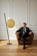 Personnage générique assis dans fauteuil club — lampadaire — intérieur parisien
